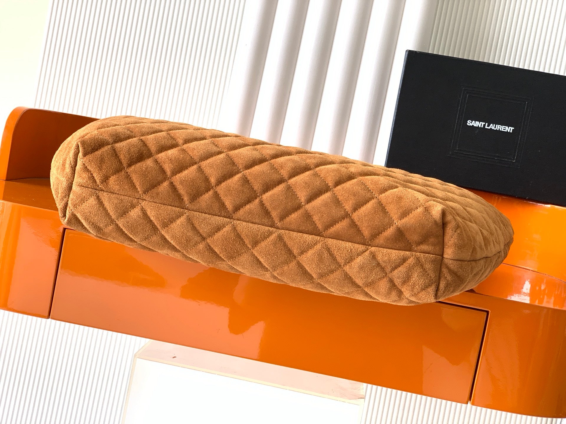 YSL quilted tote bag in tan suede, close view of quilted top and rounded edge