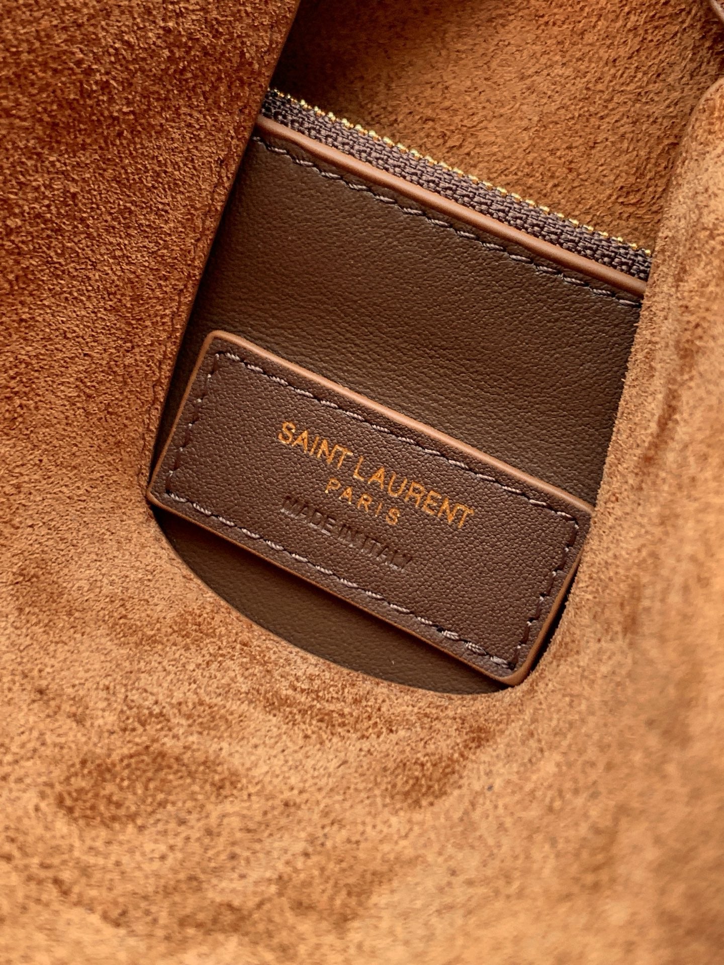 Tan suede interior pocket with brown leather label and SAINT LAURENT branding