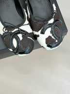Chanel ladies flats close-up, pair with black laces and metal ring charms
