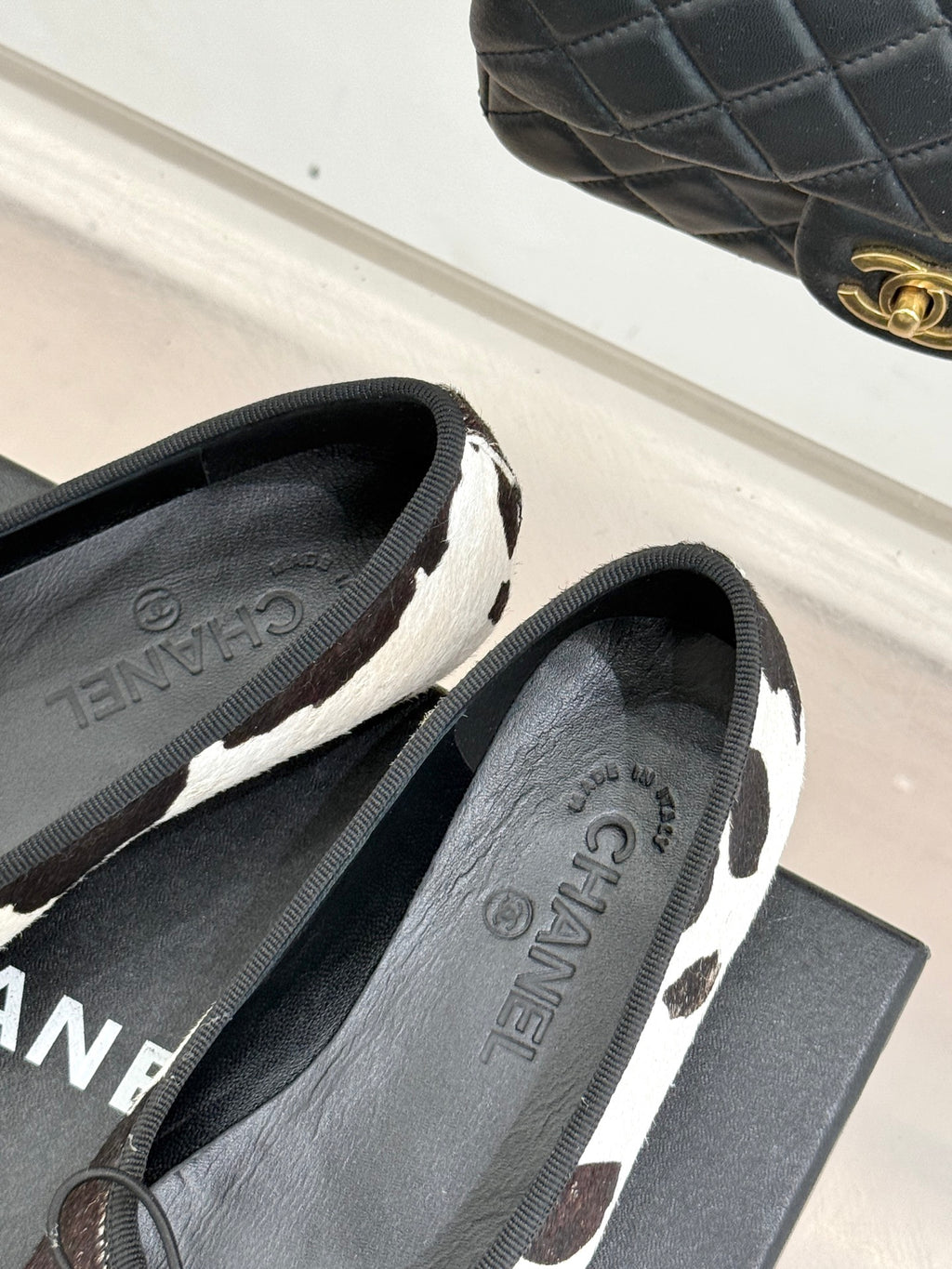 Chanel ladies flats side view, black/white cow print with CHANEL insole