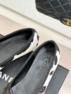 Chanel ladies flats side view, black/white cow print with CHANEL insole