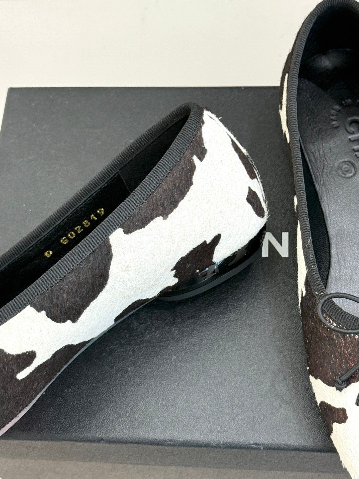 Chanel ladies flats close-up, black/white cow print upper with lace-up bow