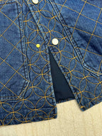 Denim jacket sleeve with blue lining and blue-and-gold lattice embroidery