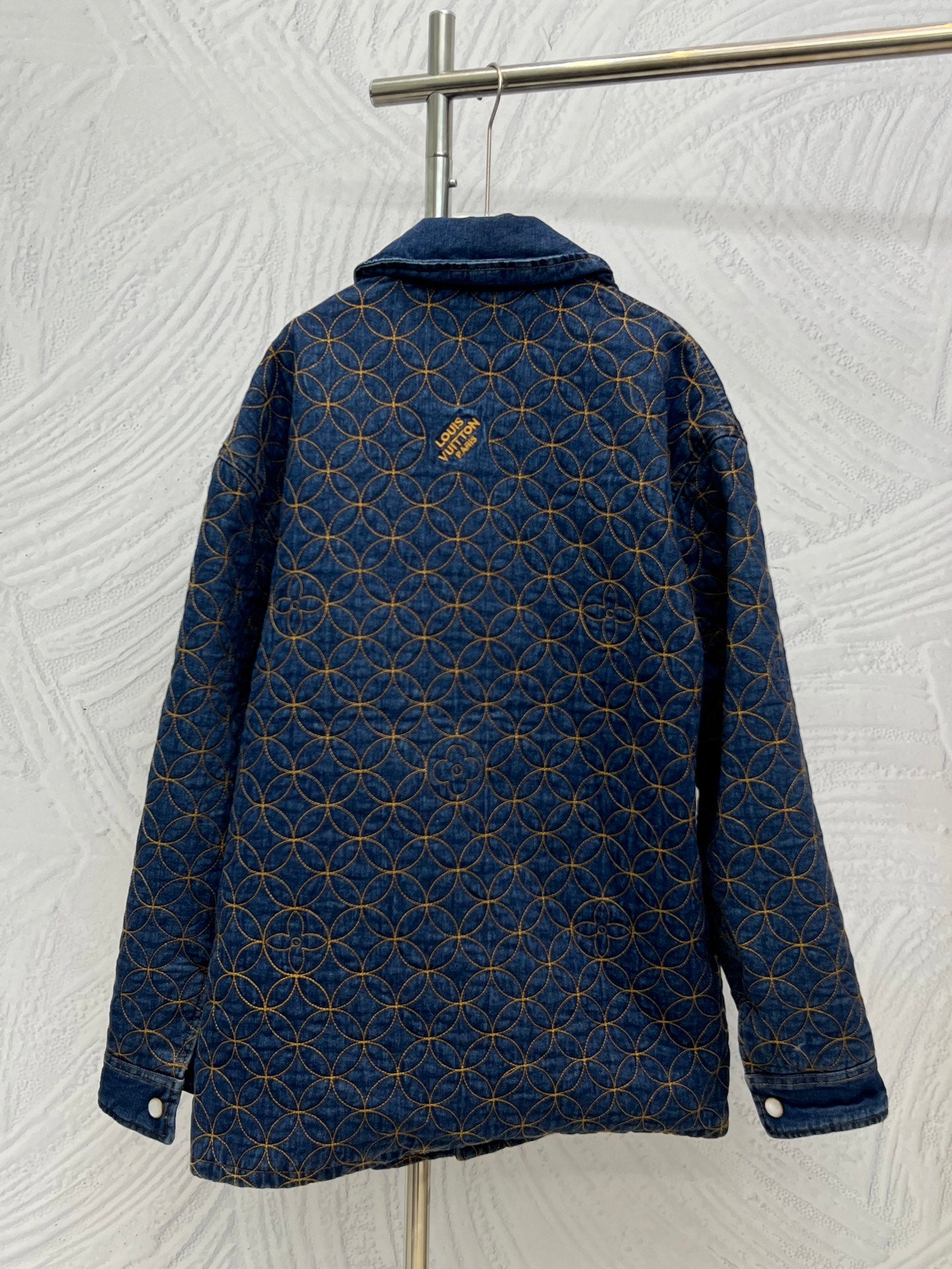 Denim jacket back with blue and gold lattice embroidery, hooded collar, button details