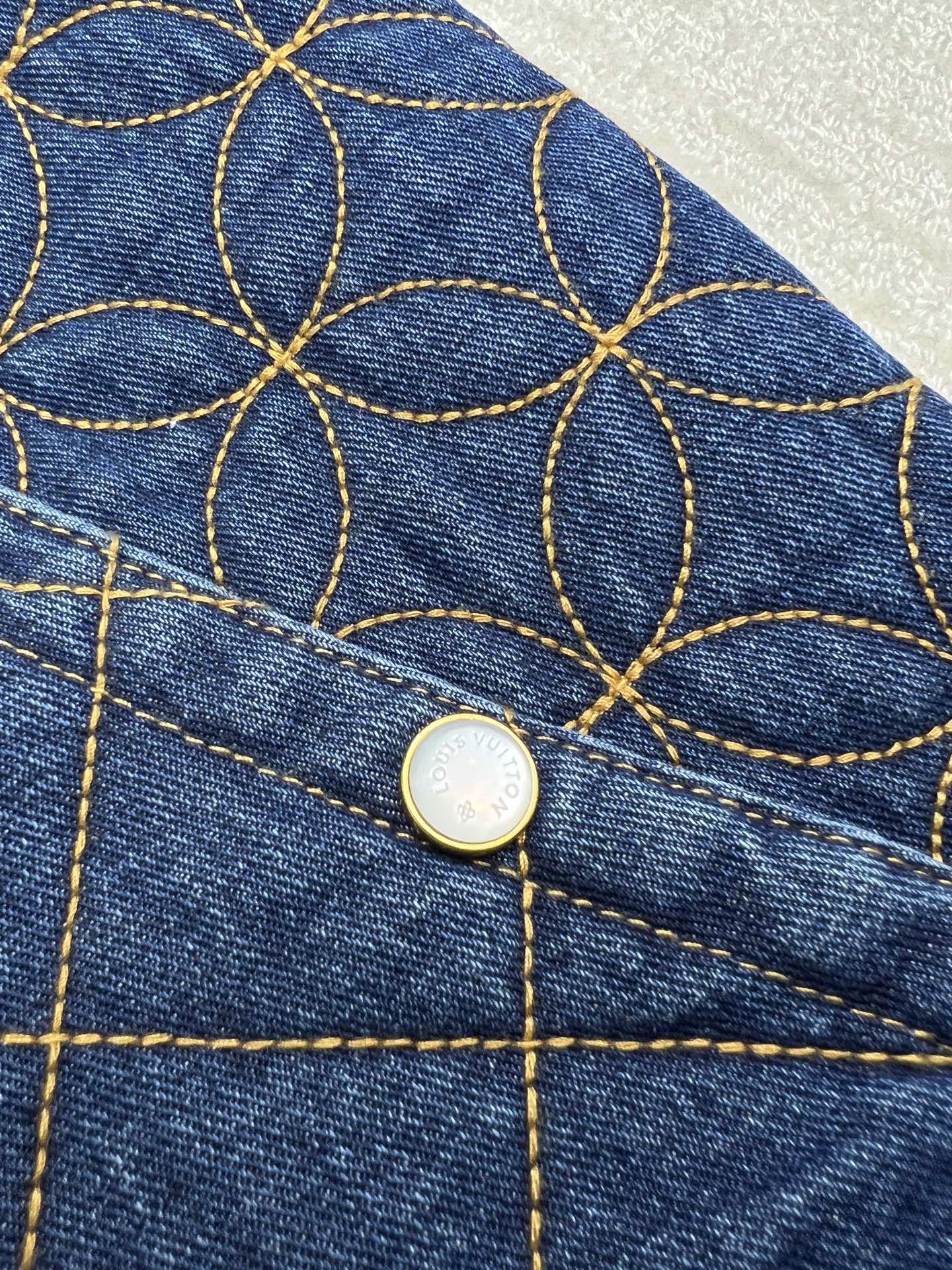 Denim jacket gold button with blue-and-gold lattice embroidery