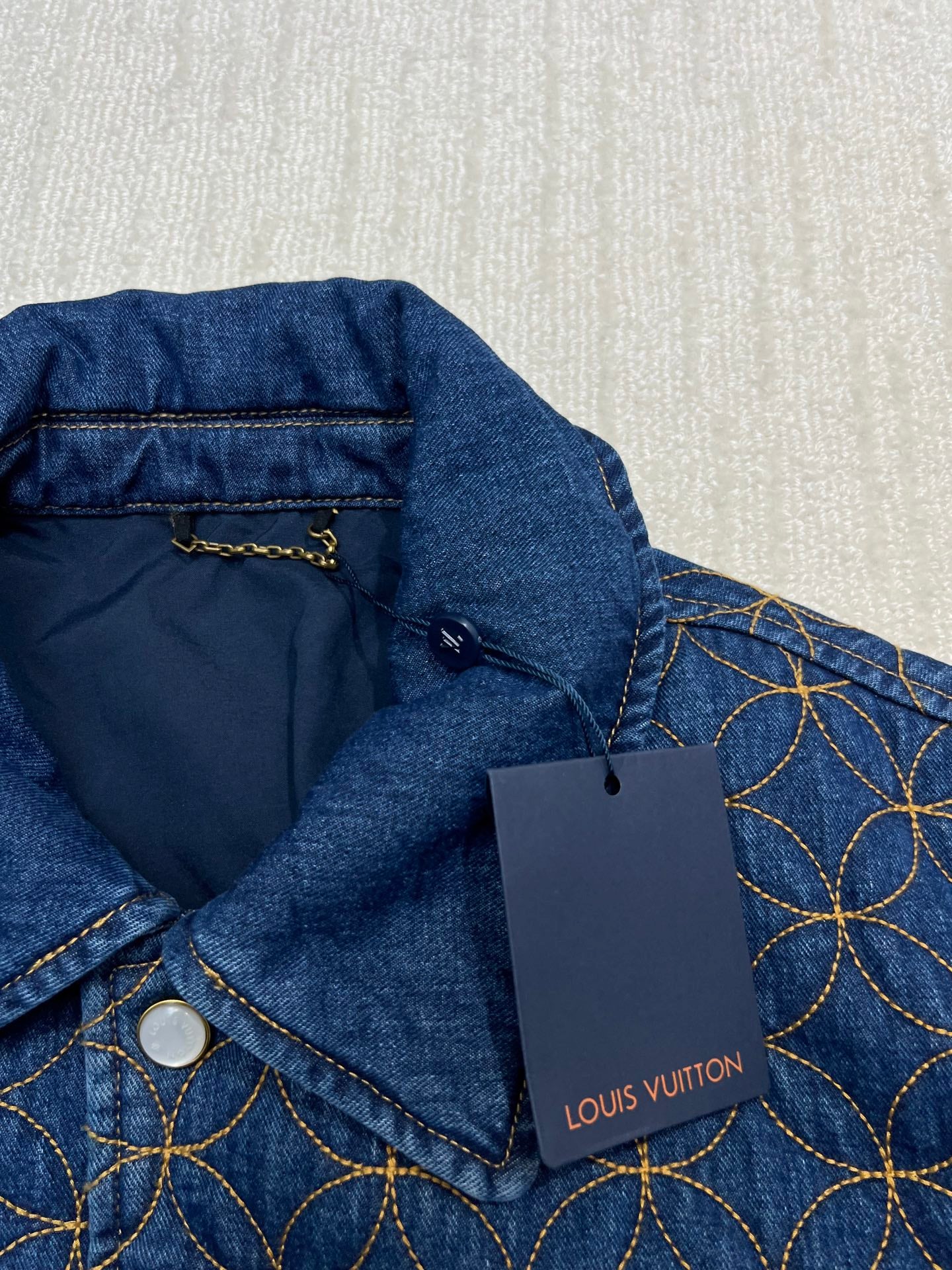 Denim jacket collar with inner lining and Louis Vuitton hang tag