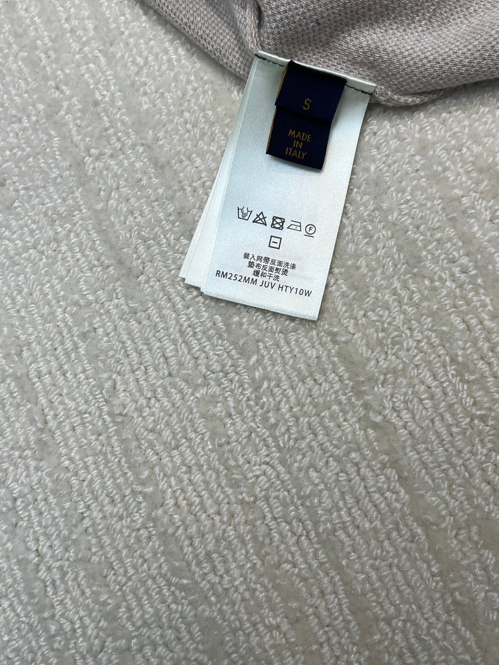 Louis Vuitton product tag on beige monogram T-shirt, size/care label
