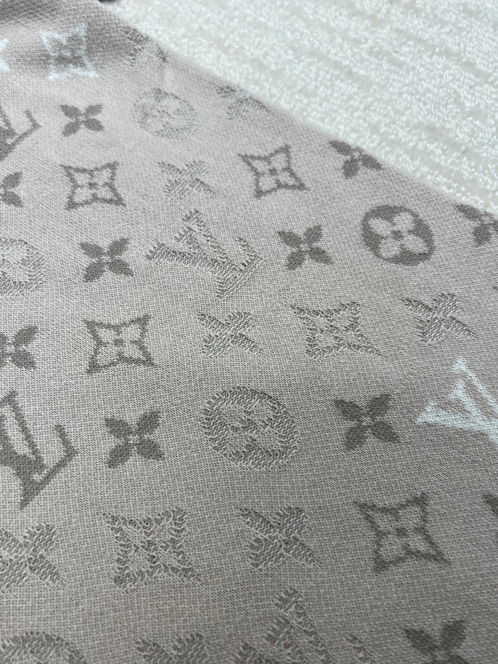 Louis Vuitton monogram T-shirt fabric close-up, light beige patterned knit
