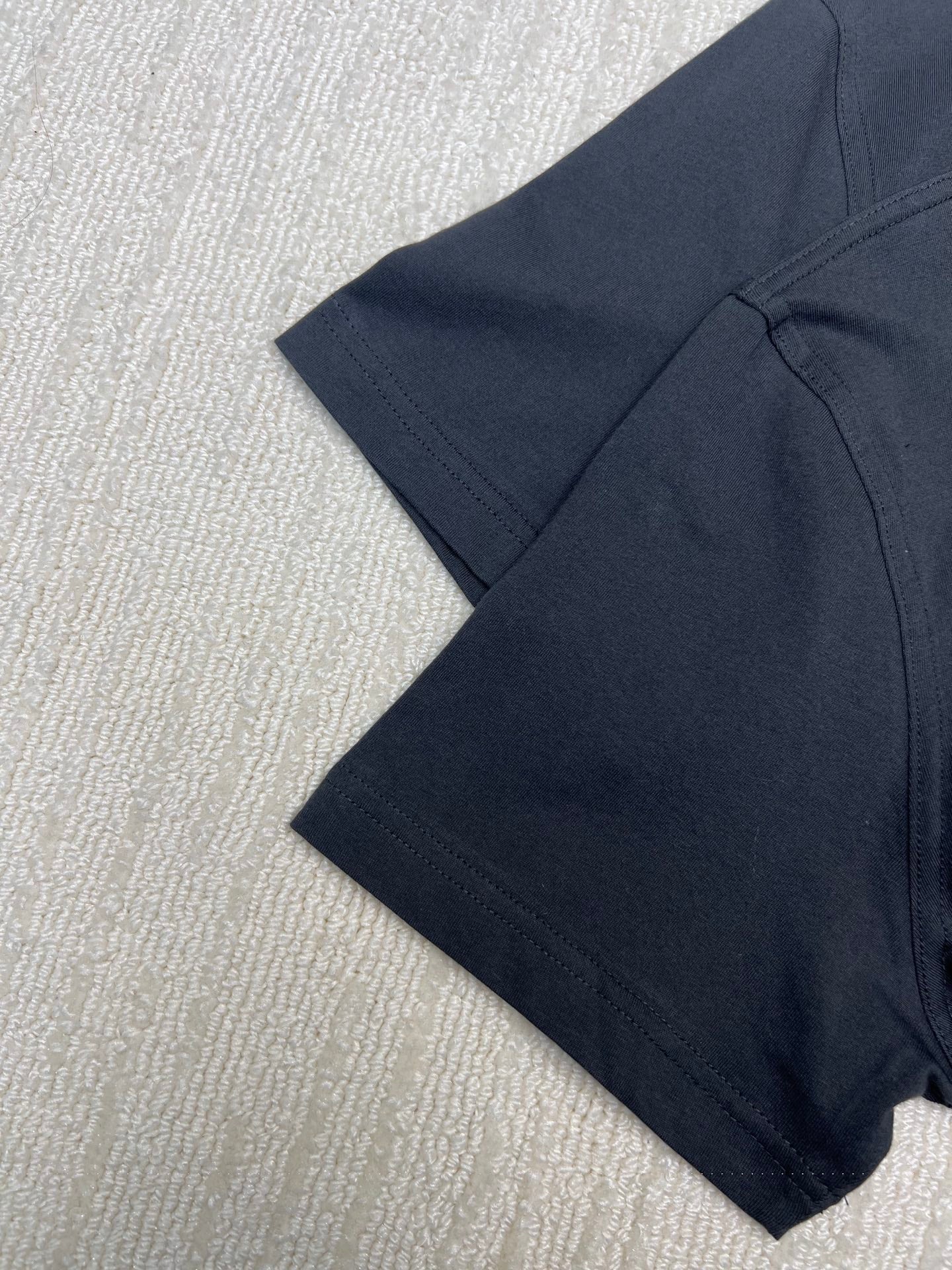 Dior T-shirt, dark; short sleeves and stitched hem, side view