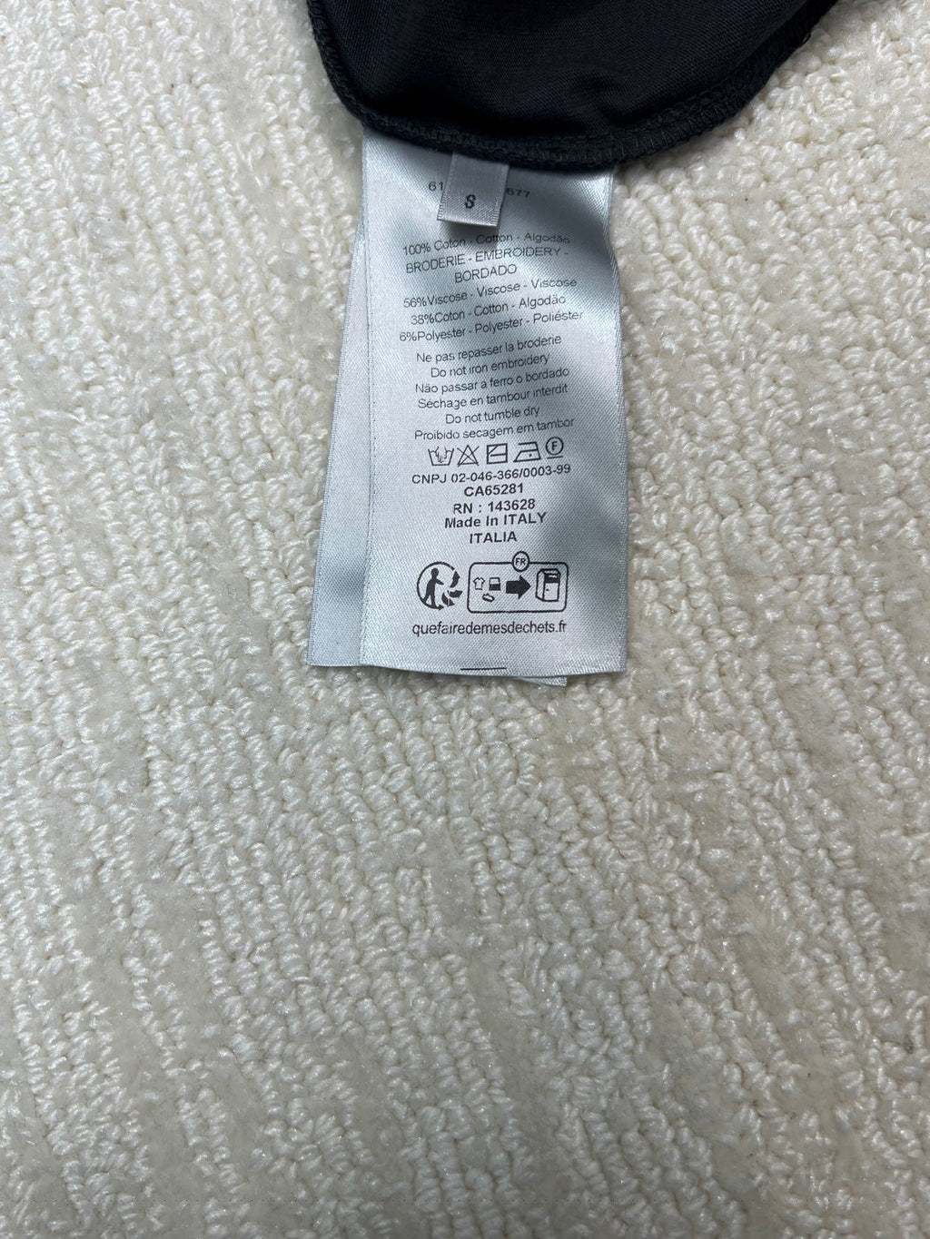 Dior T-shirt care label tag at collar, printed icons and fabric info