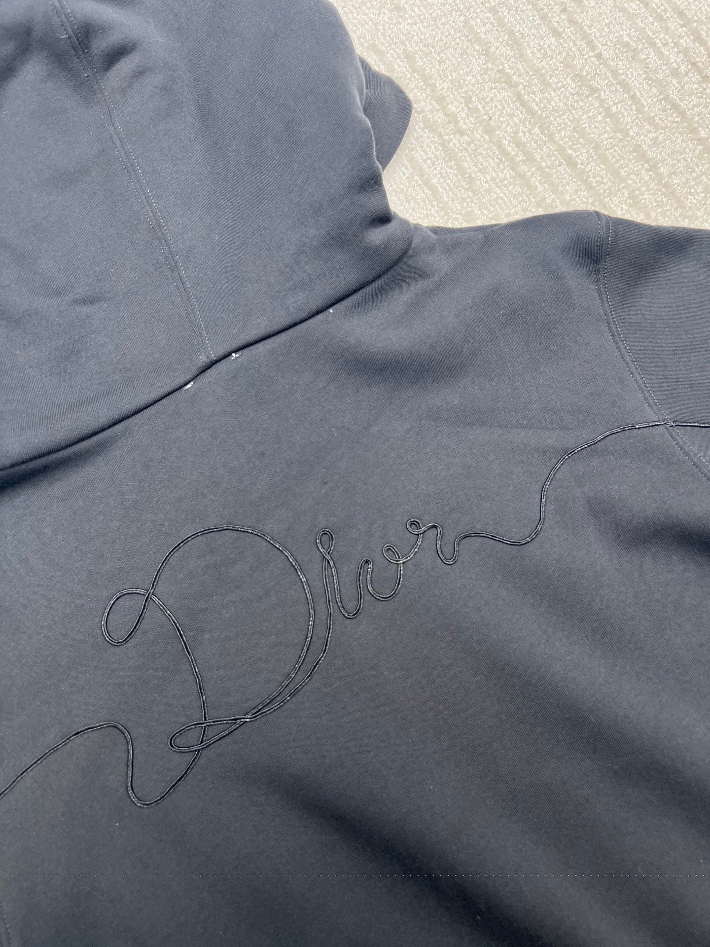 Dior hoodie shoulder-to-chest logo outline embroidery on dark navy fabric
