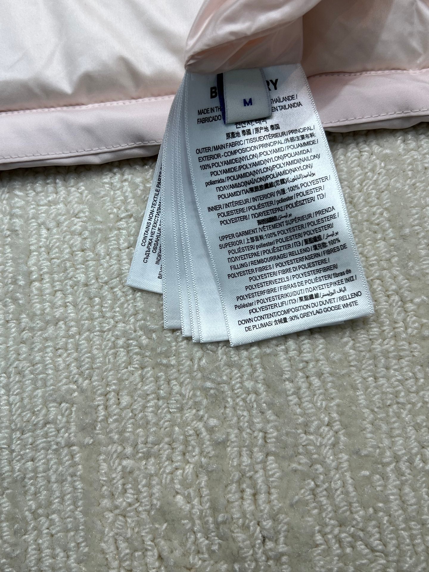 Garment care label with Burberry branding on folded fabric