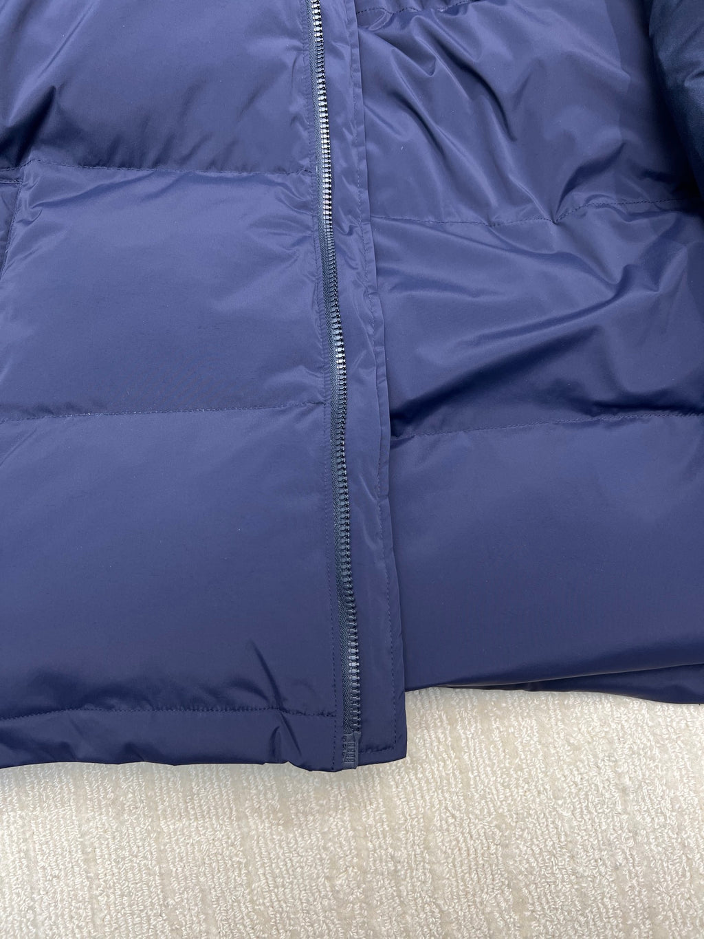 Blue puffer jacket front close-up of full zipper and padded quilting
