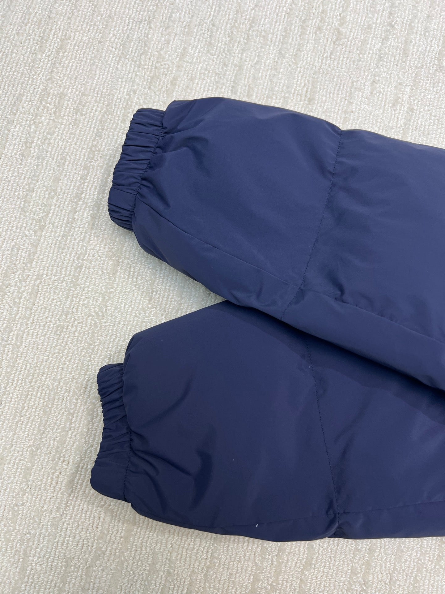 Long puffer jacket, navy, rolled sleeves on display