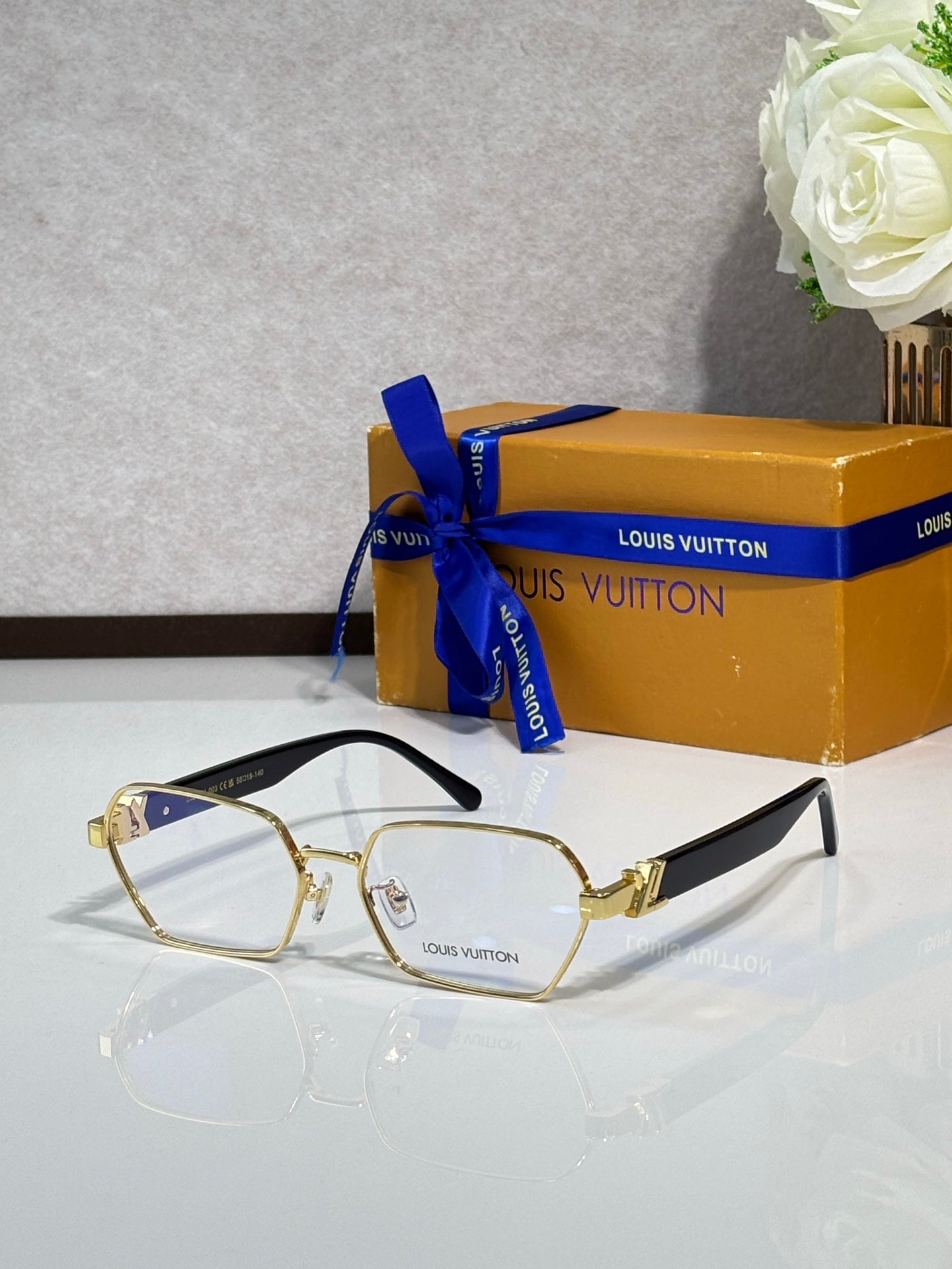 Gold-rim eyeglasses with clear lenses and gold-tone bridge hardware