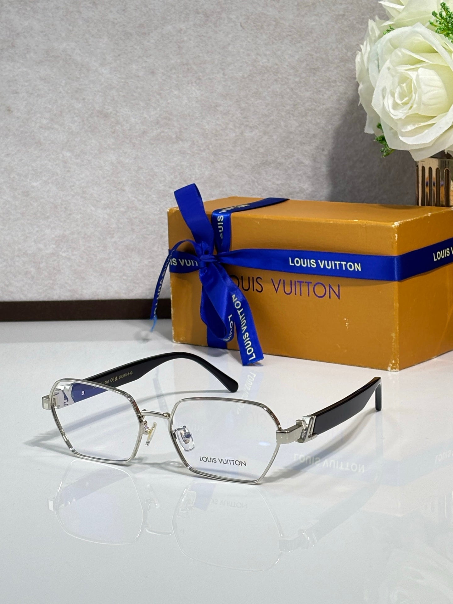 Silver-tone frame eyeglasses with clear lenses and black logo temple