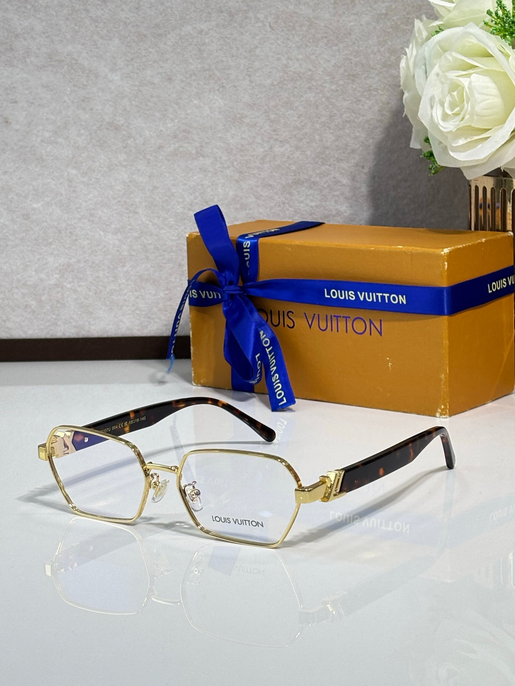 Gold-rim square eyeglasses with clear lenses and black temple tips