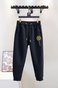 Black Versace sweatpants with elastic waistband, gold drawstrings and logo patch