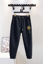 Black Versace sweatpants with elastic waistband, gold drawstrings and logo patch