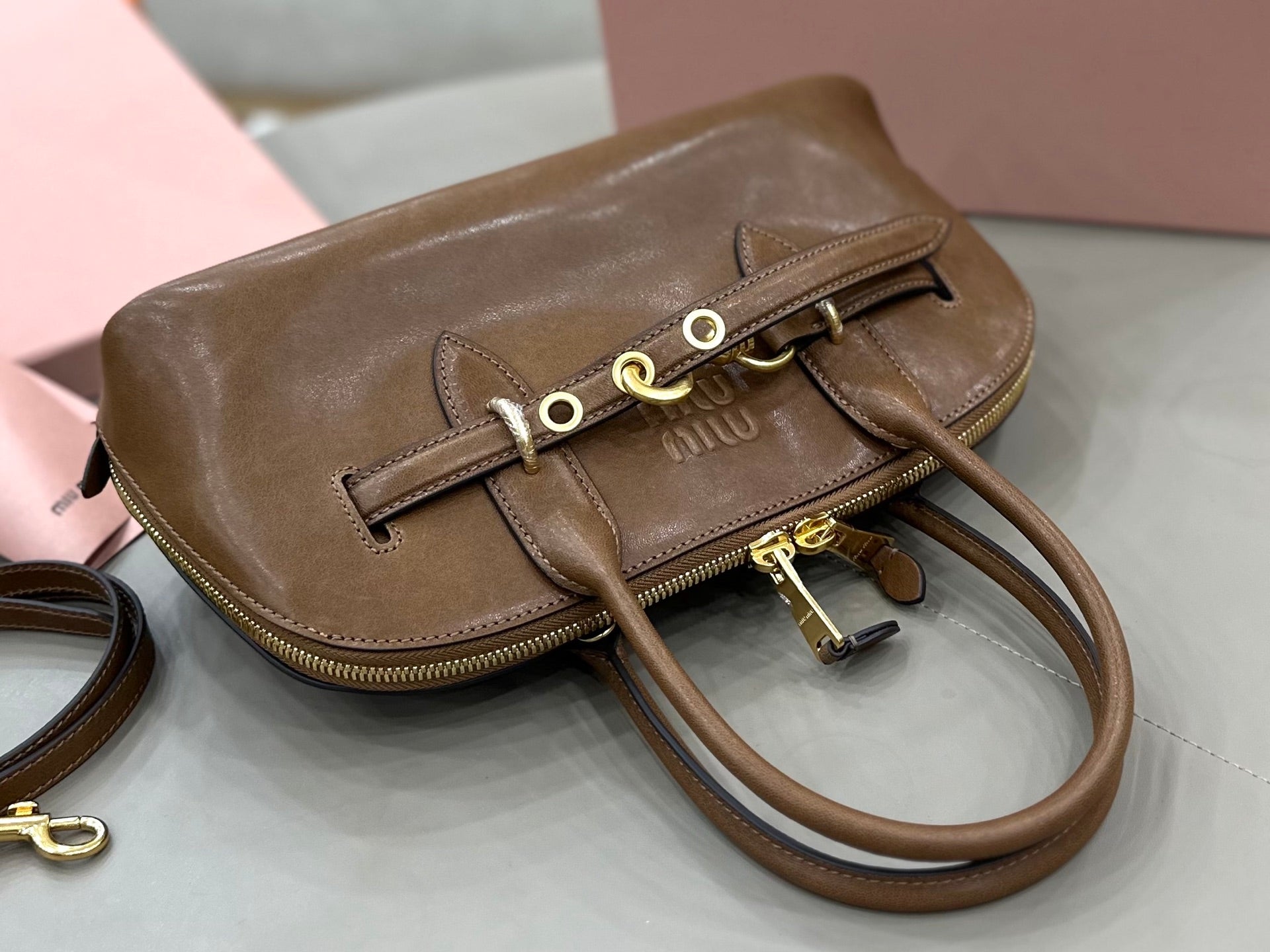 MiuMiu brown leather mini handbag with front ring clasp and shoulder strap