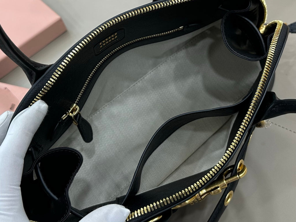 MiuMiu dark navy leather handbag open top showing light interior lining and zip closure