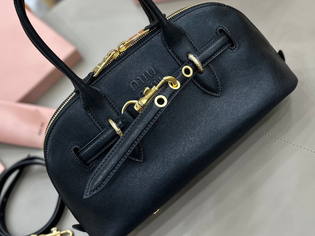 MiuMiu dark navy leather bag with front strap, gold-tone eyelets, and zip trim