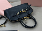 MiuMiu dark navy leather handbag with front strap, zip closure, and attached shoulder strap