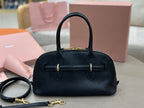 MiuMiu dark navy leather handbag with top handle, front strap detail, and gold-tone hardware