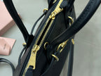 MiuMiu dark navy leather bag with visible gold-tone zipper and hardware at the side