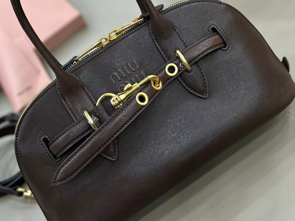 Dark leather top-handle bag with logo patch and gold-tone buckle hardware