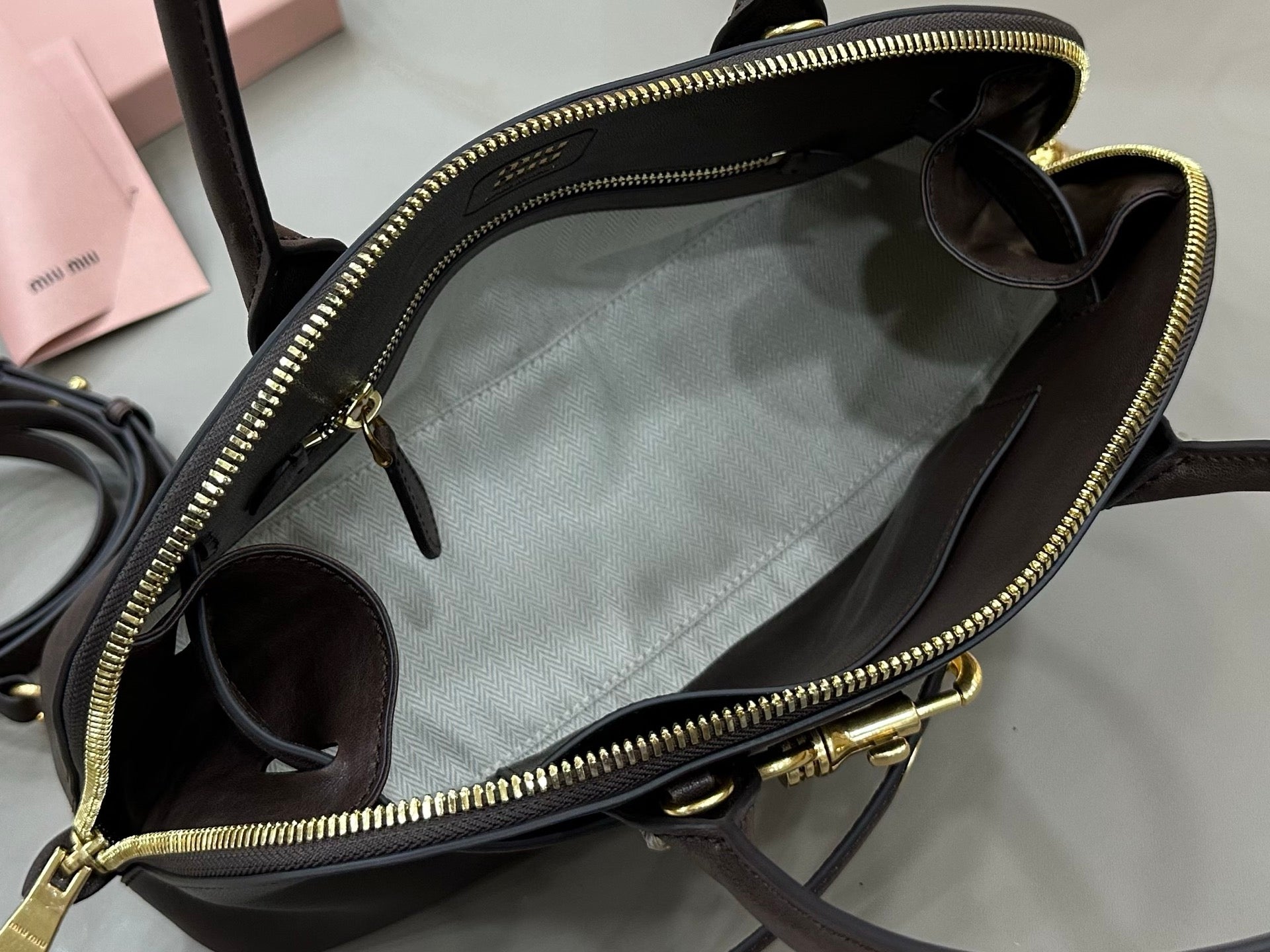 Dark leather zip-top bag open view with side pocket and top handles