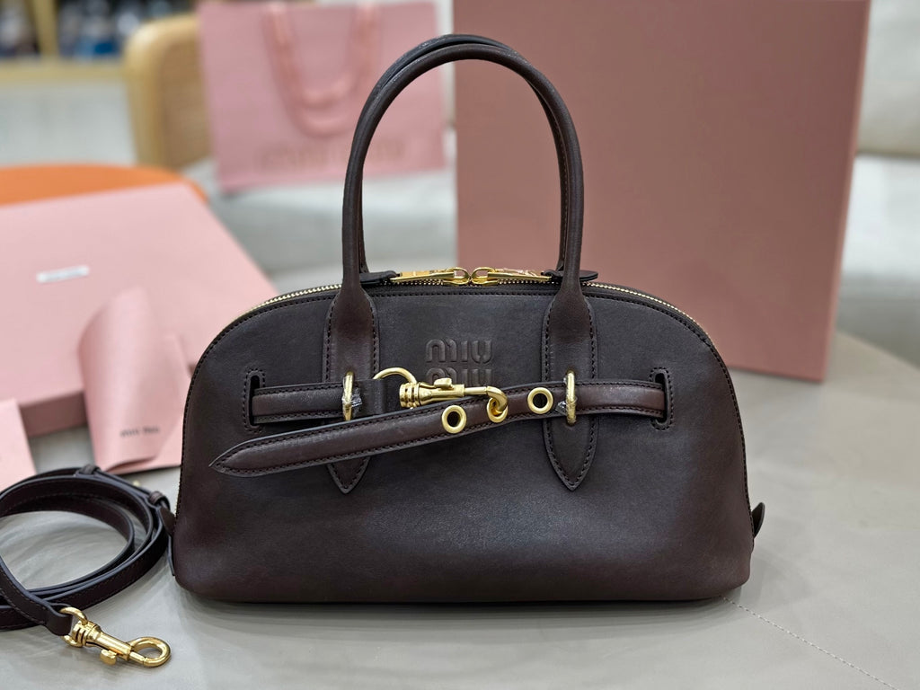 Dark leather top-handle bag with front logo plaque and gold-tone hardware