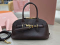 Dark leather top-handle bag with front logo plaque and gold-tone hardware