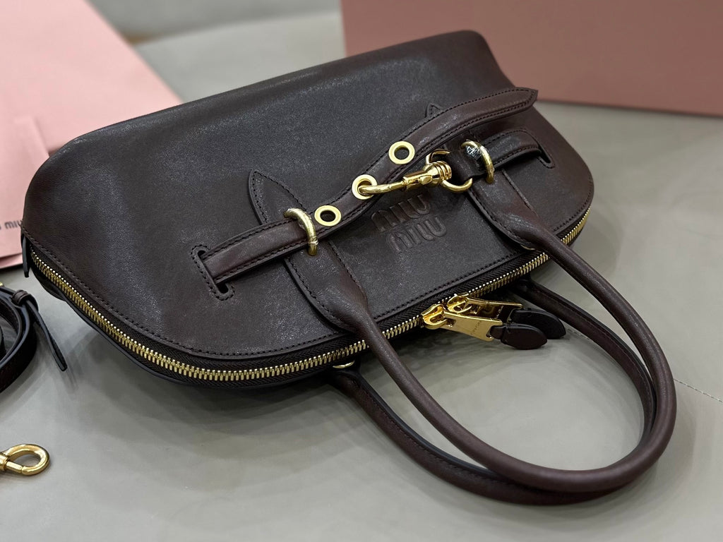 Dark leather flap-front bag with gold-tone chain clasp and crossbody strap