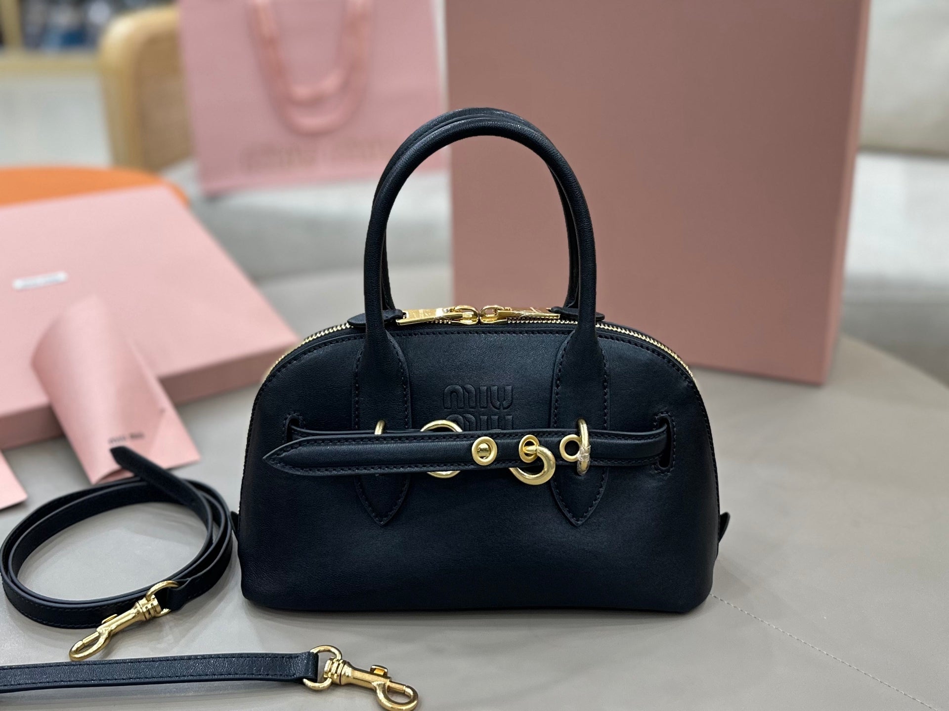 MiuMiu structured mini bag, black leather with bow clasp and gold-tone hardware