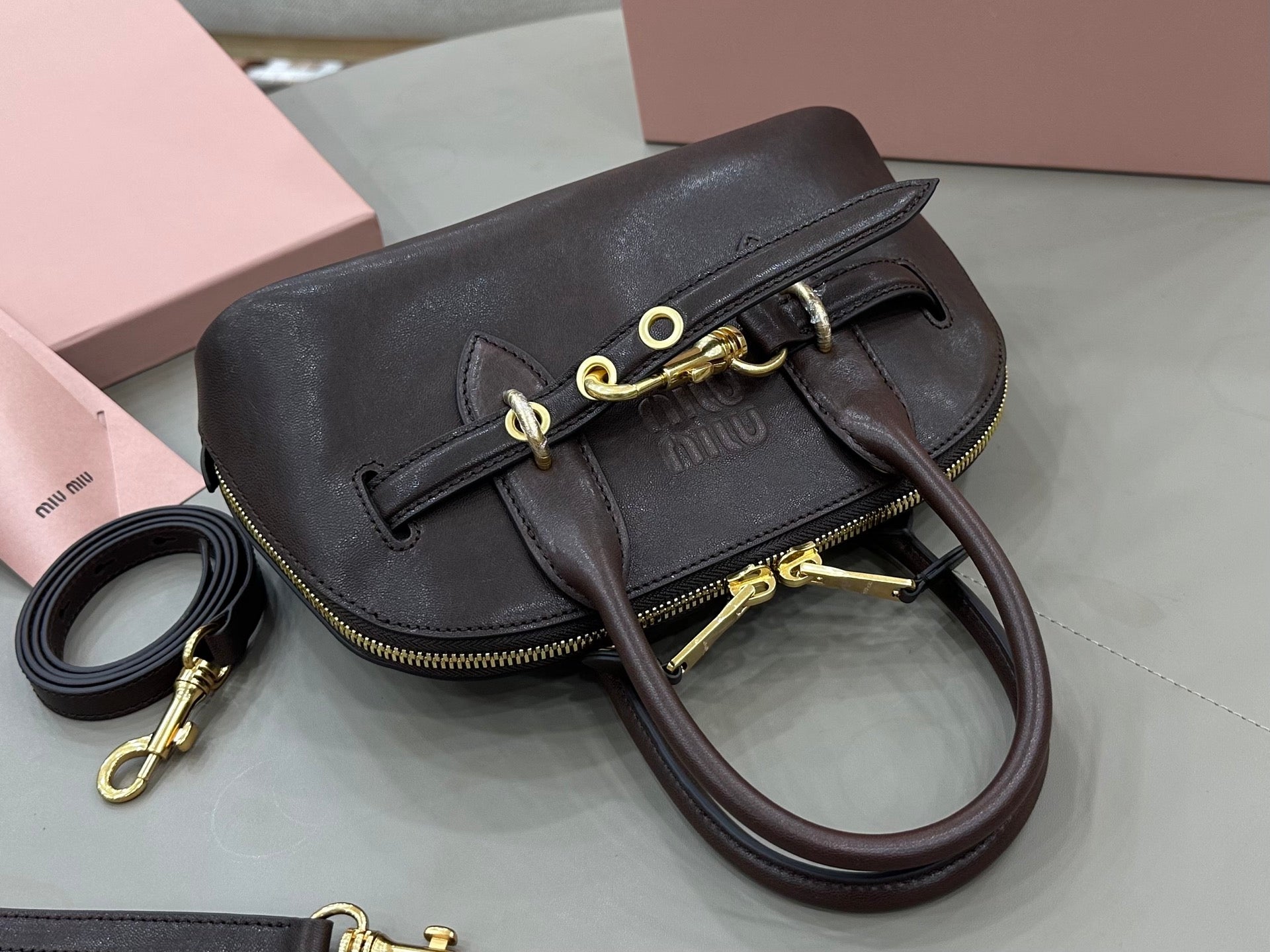 MiuMiu handbag with curved flap and gold-tone hardware, dark brown