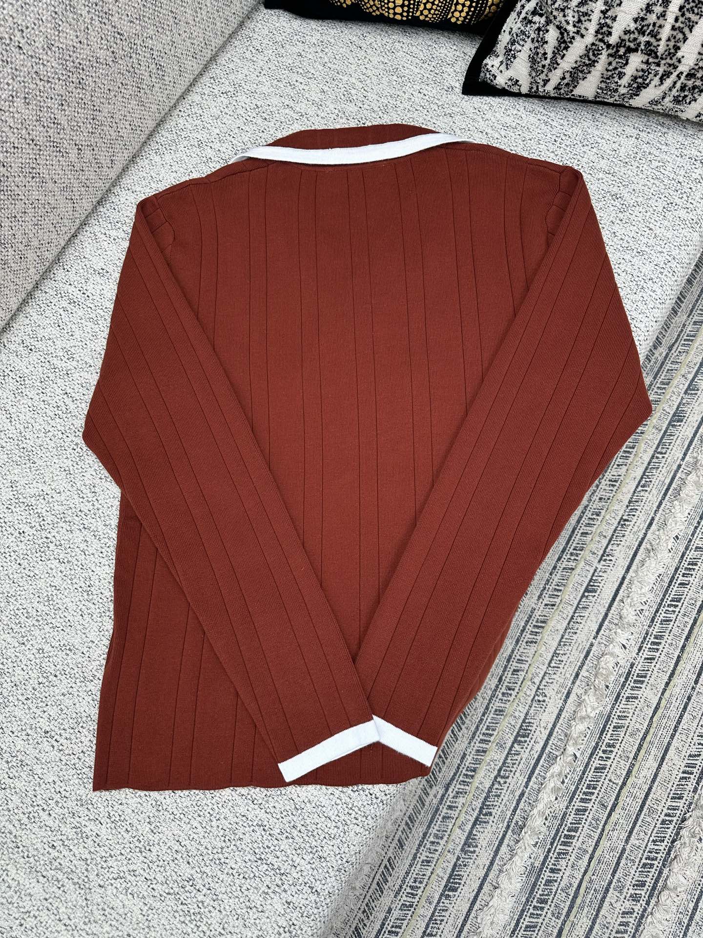 Red knit long-sleeve cardigan with white-trim cuffs, back view