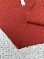 Red knit cardigan sleeve with textured ribbing and stitched seam detail