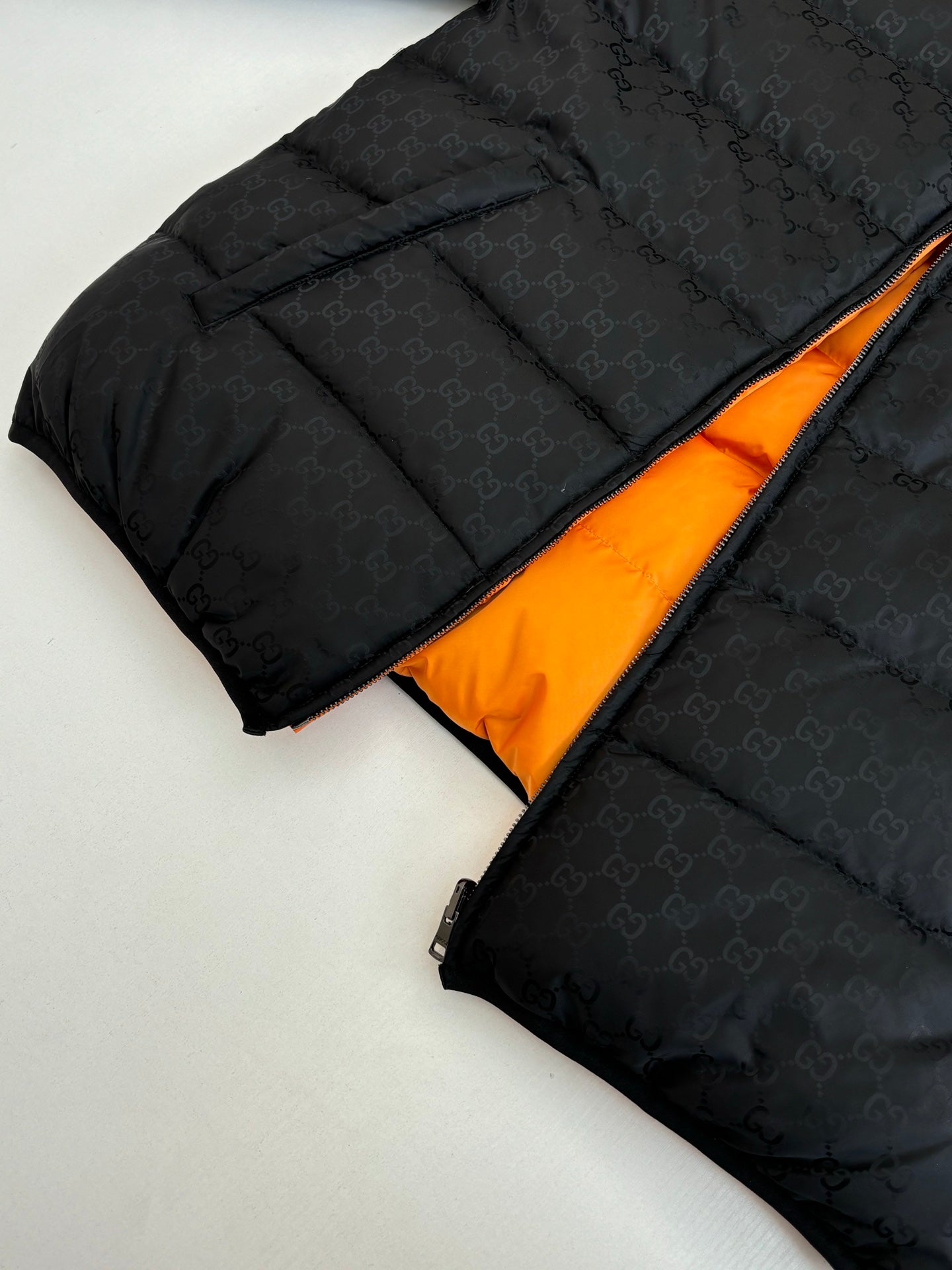 Gucci long puffer jacket in black with orange inner lining and visible zipper
