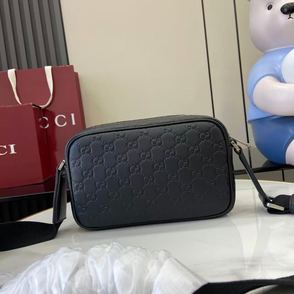 Gucci crossbody bag, dark blue embossed GG pattern, rounded shape with top zipper