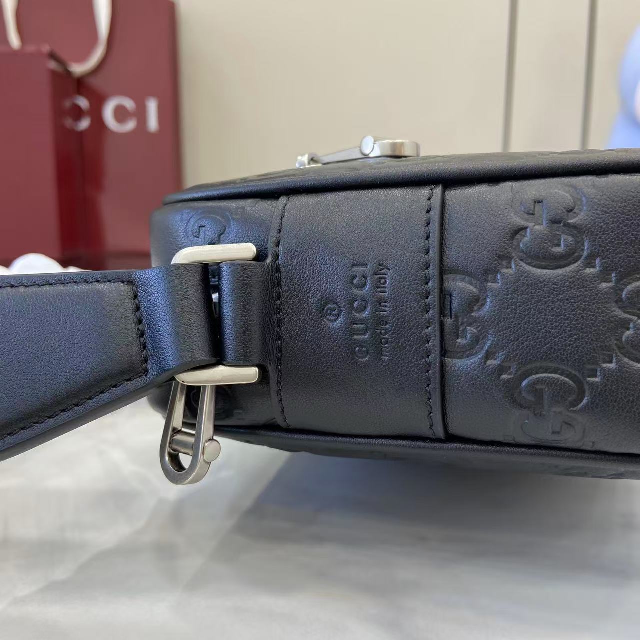 Gucci bag strap with dark leather texture and silver-tone buckle hardware
