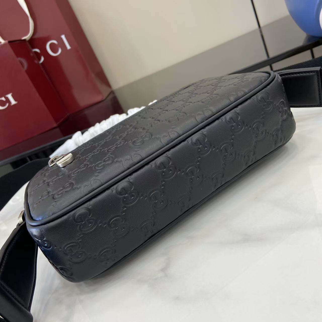 Gucci crossbody bag dark blue embossed GG pattern, long top zipper and structured sides