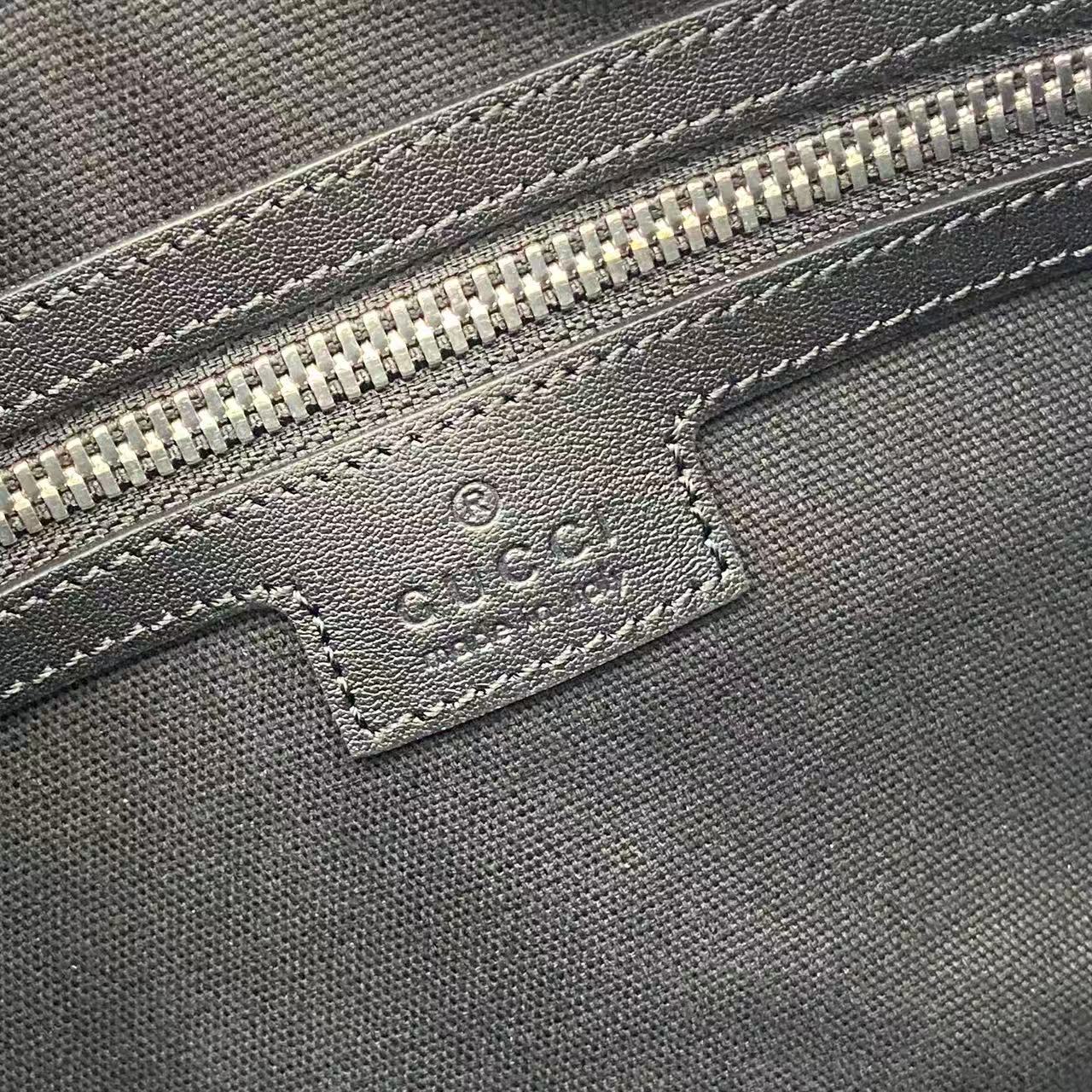 Gucci bag close-up of embossed leather label with stitching under the zipper