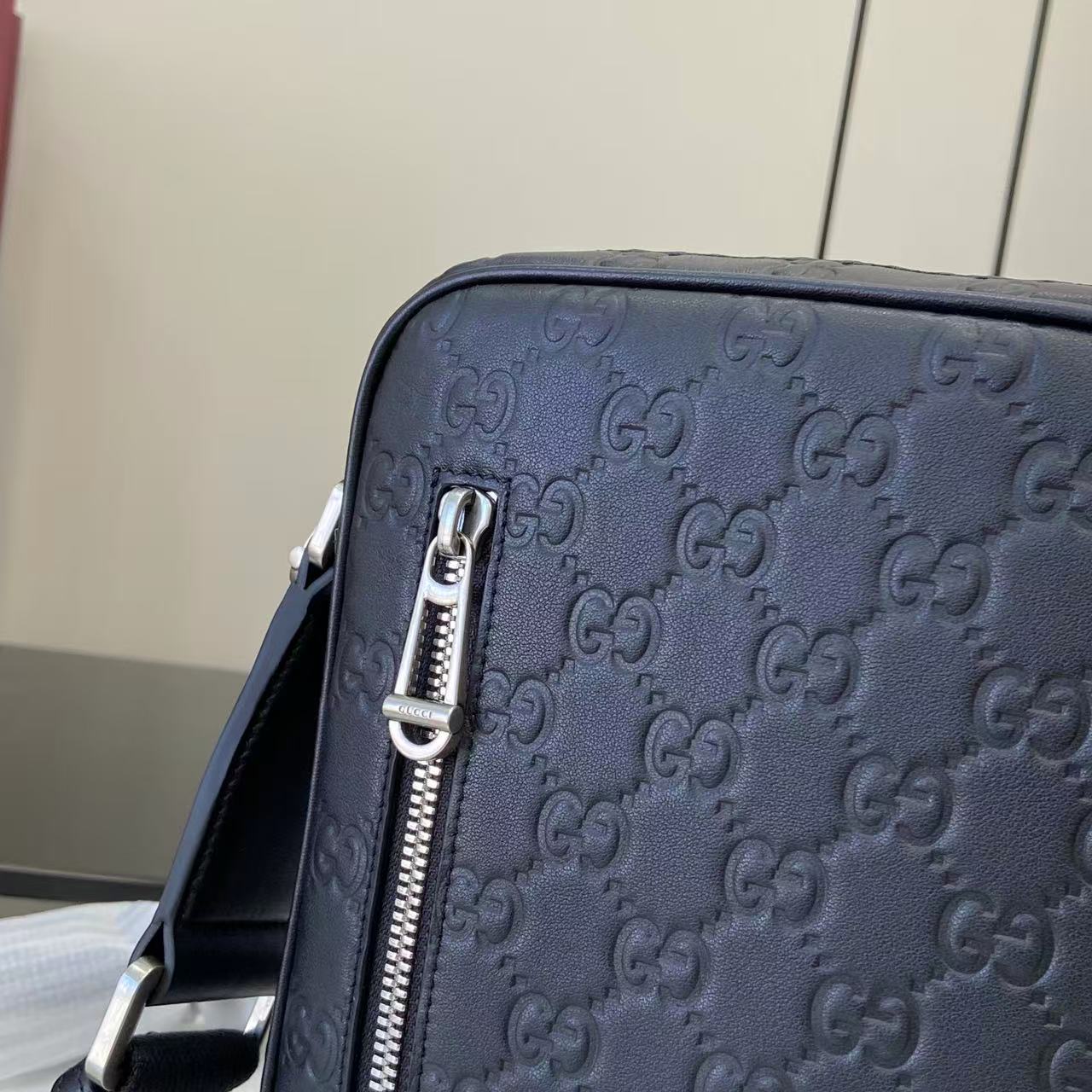 Gucci crossbody bag, top zipper hardware and embossed monogram on front