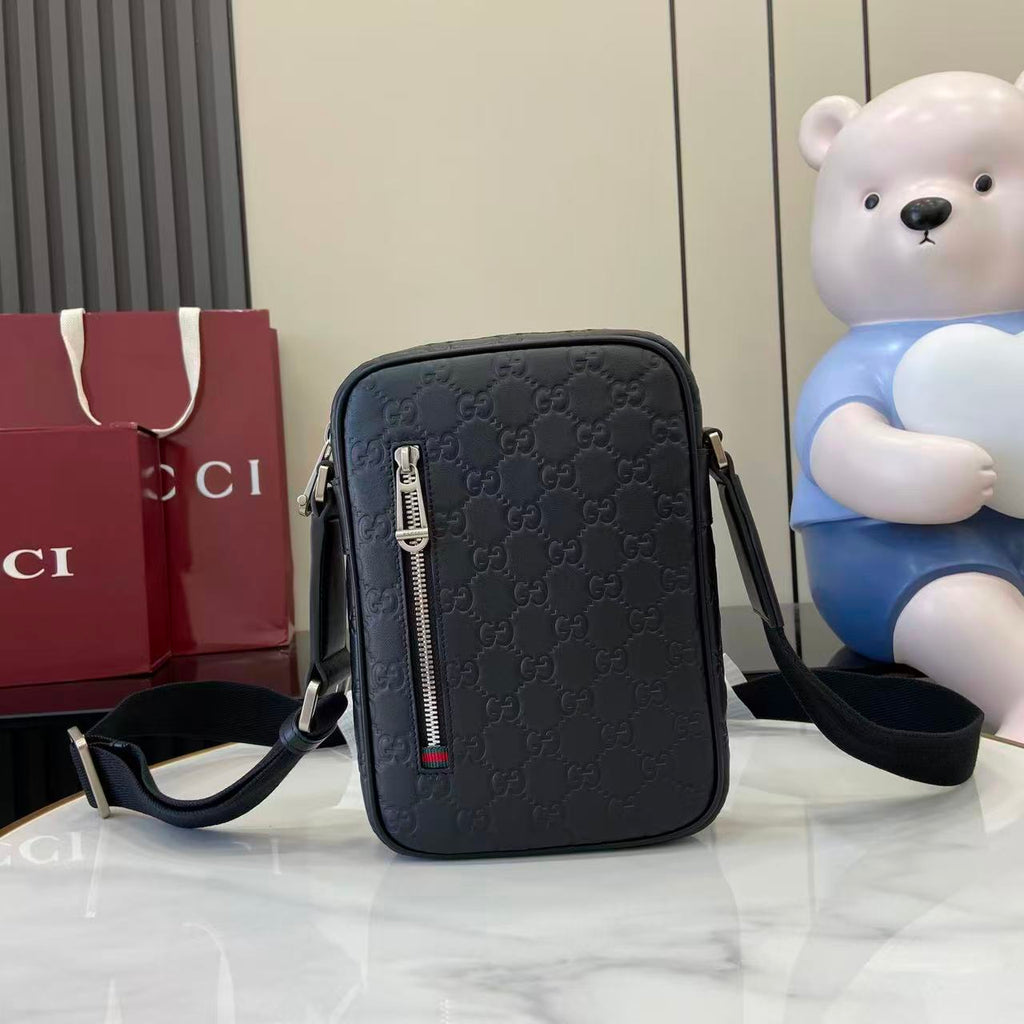 Gucci crossbody bag, embossed monogram pattern, front zip and adjustable strap