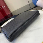 Dark navy monogram shoulder bag with long strap and zip closure, side view