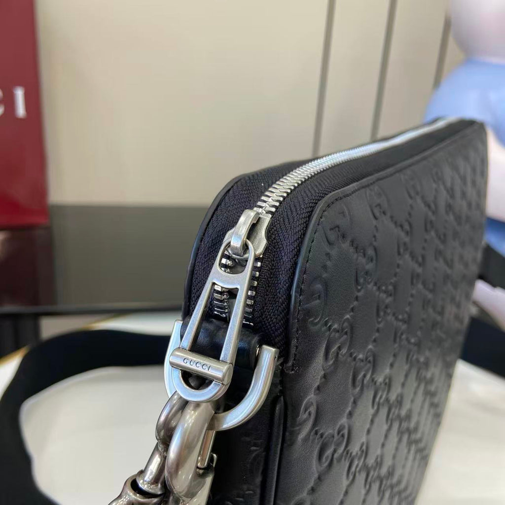 Navy crossbody bag close-up: silver zipper pull and metal D-ring hardware