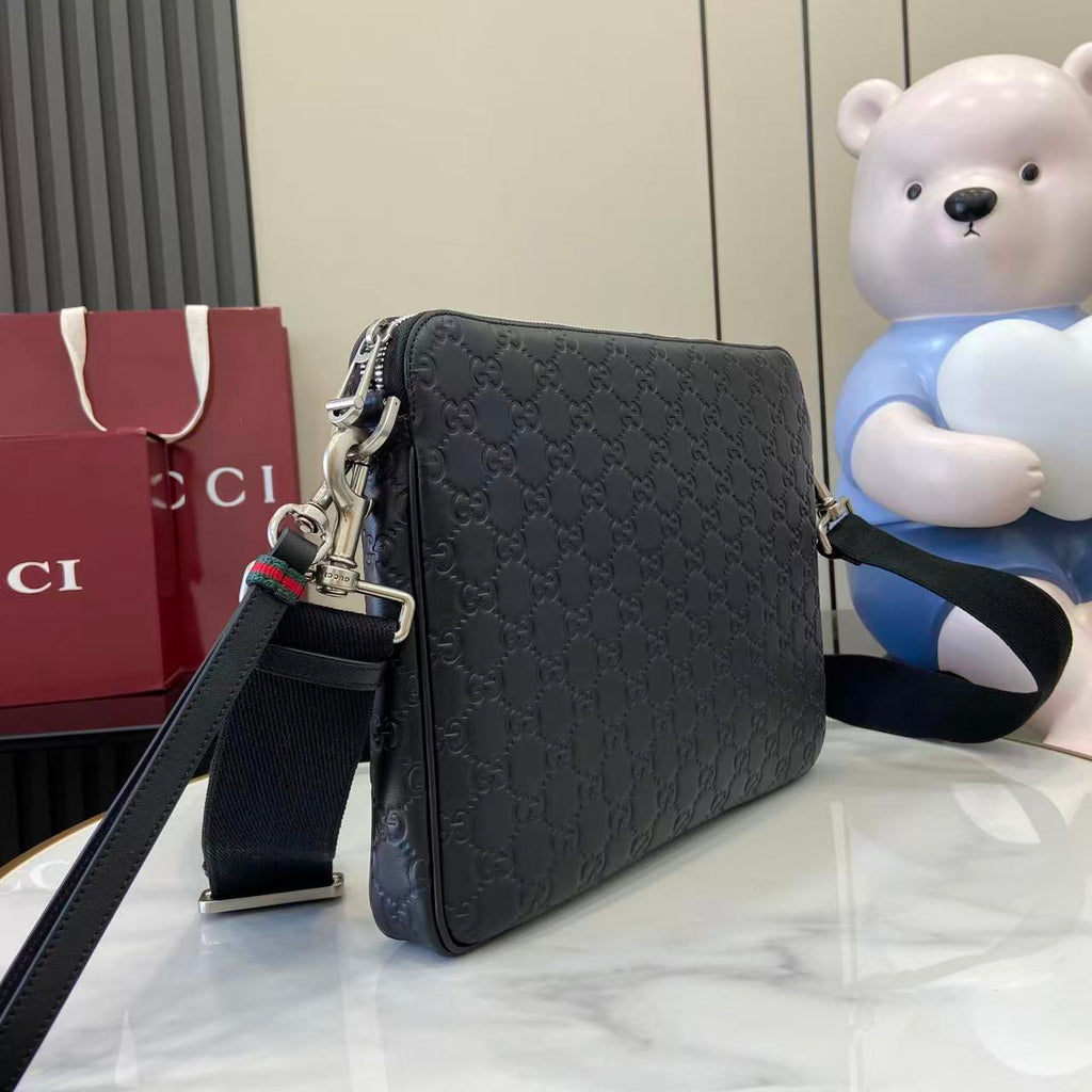 Dark navy monogram crossbody bag with zip top, chain strap, and metal hardware