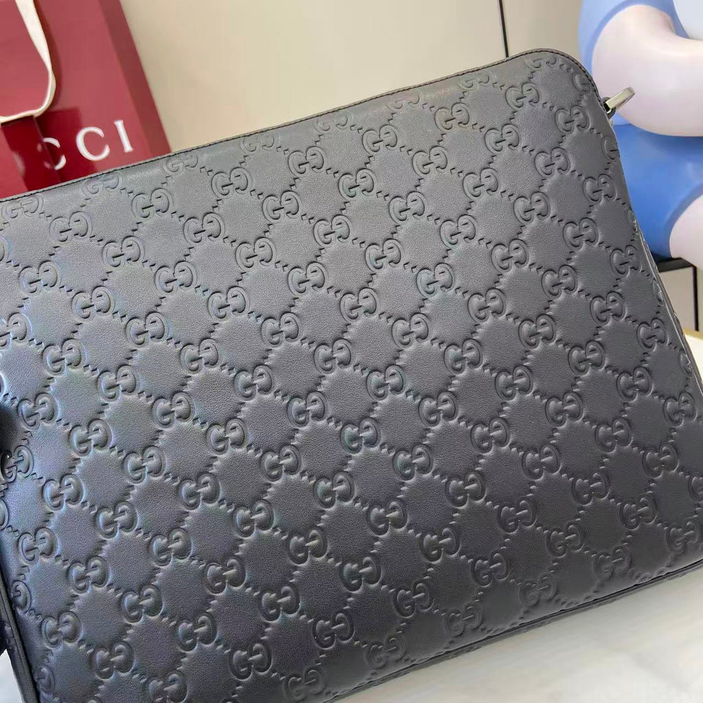 Dark navy monogram clutch bag with zip top and embossed GG pattern