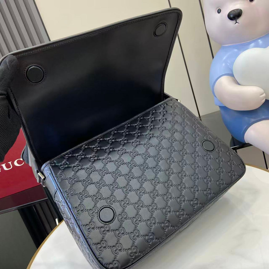 Blue embossed GG crossbody bag with metal eyelets and black lining visible